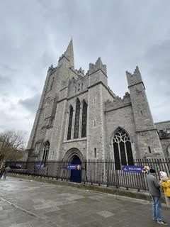 The grey stone spires and Gothic windows of St. Patrick's Cathedral in Dublin, Ireland, on an overcast day