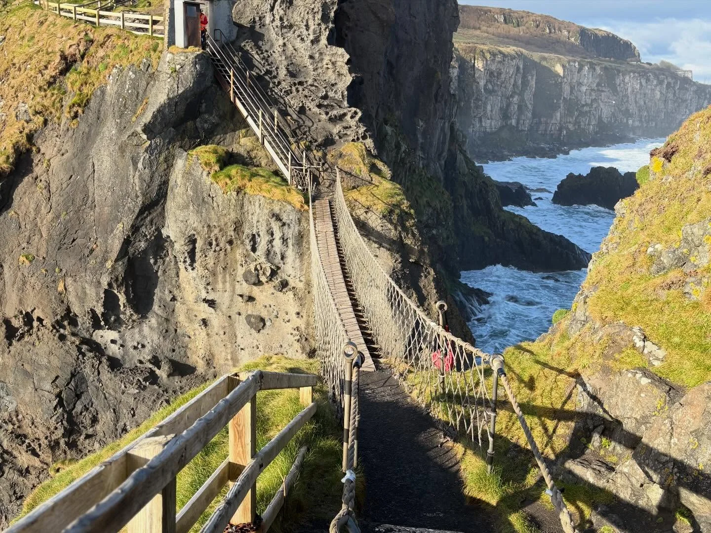 The Carrick-a-Rede rope bridge stretching across a chasm between steep coastal cliffs in Northern Ireland